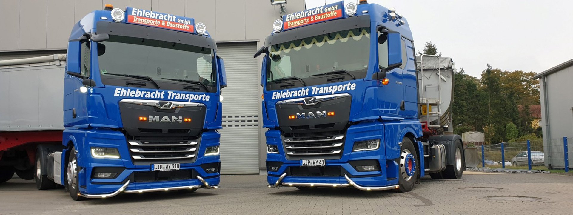 Zwei blaue LKW von Ehlebracht Transporte und Baustoffe auf dem Betriebshof in Augustdorf